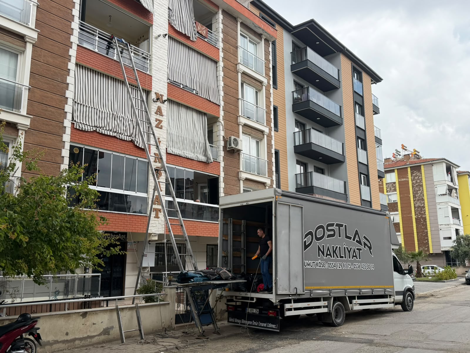 Ekip vinç ile üst kat eşyalarını indirirken